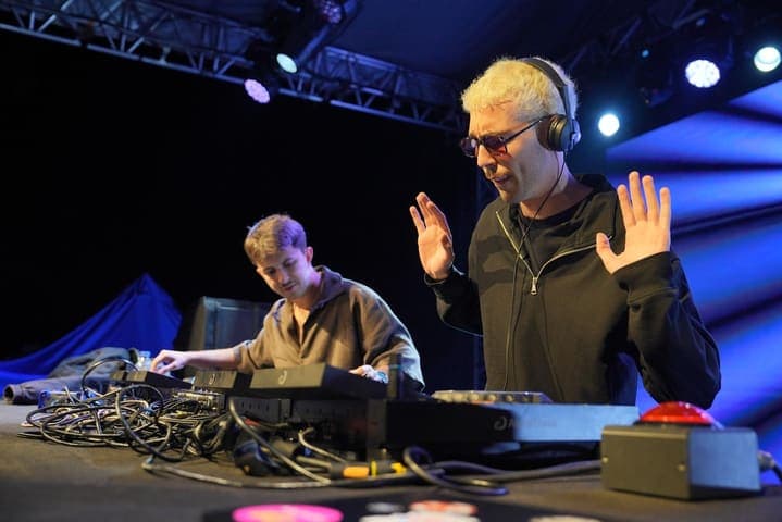 Mavi ışıkta sahnede iki DJ